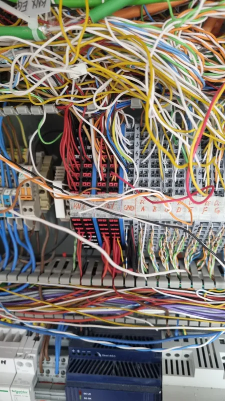 Dicht belegte Klemmen mit vielen bunten Leitungen im Verteiler