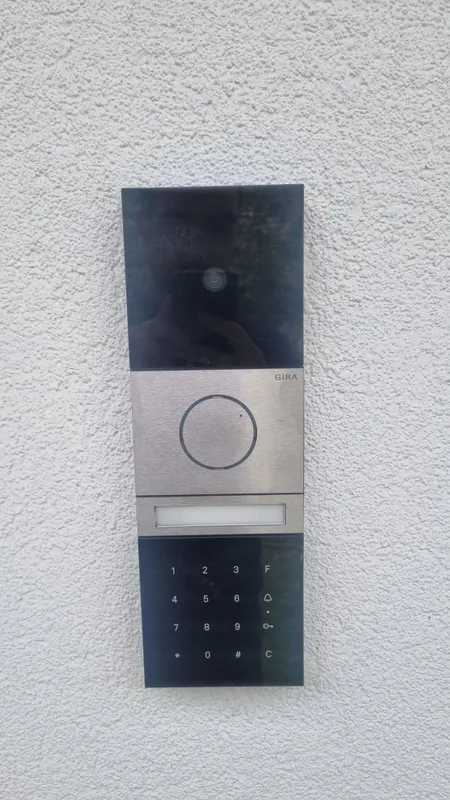 Gira-Türstation mit Kamera, Klingeltaste und Codetastatur an der Hauswand